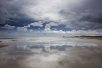 Reflection of clouds on beach at low tide — Stock Photo