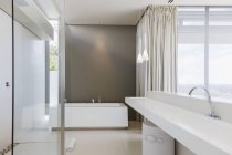 Pia e banheira no interior do banheiro moderno — Fotografia de Stock