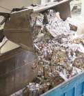 Ведро сбрасывает переработанные пачки в мусорное ведро — стоковое фото