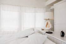 Живописный вид лампы оболочки в белой спальне — стоковое фото