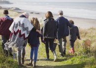 Famiglia multi-generazione a piedi sul sentiero di spiaggia di erba soleggiata — Foto stock