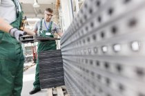 Arbeiter heben Stahlteile in Fabrik — Stockfoto