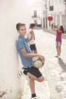 Мальчик держит футбольный мяч в переулке — стоковое фото