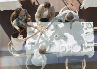 Freunde stoßen an sonnigem Restauranttisch auf Weingläser an — Stockfoto