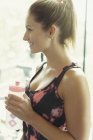 Lächelnde Frau trinkt Wasser im Fitnessstudio — Stockfoto