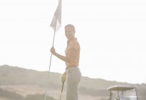 Caucasiano jovem mulher segurar bandeira de golfe — Fotografia de Stock