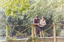 Vater und Sohn stehen auf Holzbrücke über Fluss — Stockfoto