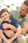 Father and son hugging outdoors — Stock Photo