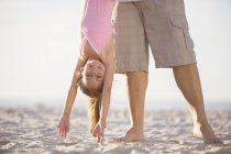 Father and daughter playing on beach — Stock Photo