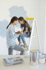 Мать и дочь рисуют стену синей — стоковое фото