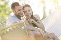 Прихильна молода пара посміхається в літньому гамаку — стокове фото
