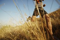 Человек бежит по высокой траве по солнечной тропе — стоковое фото