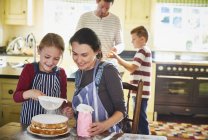 Familie in Küche drinnen bereitet Essen und Kuchen zu — Stockfoto