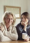 Retrato sorrindo mãe e filha em suéteres bebendo café — Fotografia de Stock