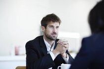 Успешные взрослые бизнесмены разговаривают в кафе — стоковое фото