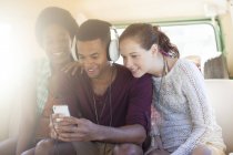 Friends listening to mp3 player in camper van — Stock Photo