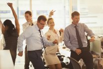Empresarios entusiastas celebrando y bailando en la oficina - foto de stock