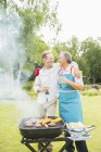 Hommes heureux étreignant au barbecue dans la cour — Photo de stock