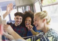 Enthusiastic friends taking selfie on bus — Stock Photo
