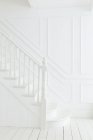 Banister and staircase in white foyer — Stock Photo