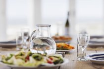 Nahaufnahme von Essen und Wasser auf gedecktem Tisch — Stockfoto