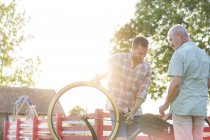 Father and adult son fixing bicycle — Stock Photo