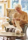 Lächelnde Seniorin strickt Schal — Stockfoto