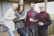 Portrait smiling couples drinking coffee on porch — Stock Photo