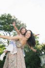 Portrait carefree mother piggybacking daughter with arms outstretched — Stock Photo