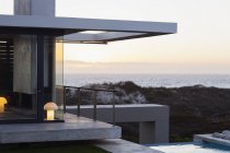 Современный дом с видом на океан на закате — стоковое фото