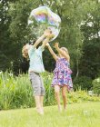Niños felices jugando con burbuja al aire libre - foto de stock
