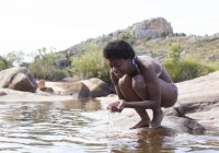 Frau schröpft Wasser in Fluss — Stockfoto