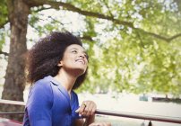 Carefree woman with afro riding double decker bus and looking up — Stock Photo