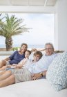 Älteres Paar mit Enkeln auf dem Sofa — Stockfoto