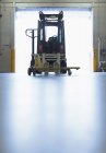 Forklift parked in warehouse loading dock doorway — Stock Photo