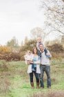 Retrato sonriente familia en el parque de otoño - foto de stock
