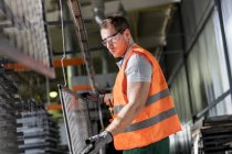 Arbeiter hält Stahlteil in Fabrik — Stockfoto