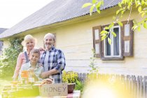 Portrait fier grands-parents et petit-fils vendant du miel — Photo de stock