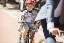Retrato sorridente menino andar de bicicleta na estrada ensolarada — Fotografia de Stock