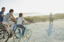 Bicicletas familiares en la playa soleada - foto de stock