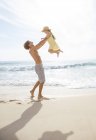 Padre e hija jugando en la playa - foto de stock