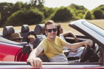 Porträt lächelnder Mann im Cabrio mit Familie — Stockfoto