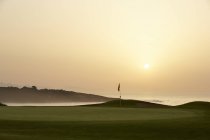 Vue panoramique du coucher de soleil sur l'océan et le terrain de golf — Photo de stock