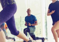 Smiling man lunging in exercise class — Stock Photo