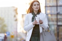 Geschäftsfrau spaziert mit Kaffee durch die Stadt — Stockfoto