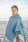 Girl wrapped in towel on beach — Stock Photo