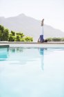 Junge attraktive Frau praktiziert Yoga am Pool — Stockfoto