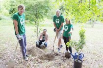 Portrait of confident environmentalist volunteers planting new tree — Stock Photo