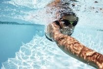 Male swimmer athlete swimming underwater in swimming pool — Stock Photo