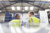 Supervisor and worker talking in steel factory — Stock Photo
